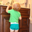 Toddler reaching up to bathroom counter.