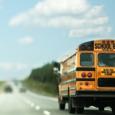 A side view of a school bus on the road. 