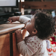 toddler reaching on top of media center to tv
