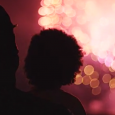 parent and child watch fireworks display from a distance