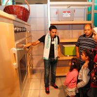Safe Kids staff demonstrates an oversized model kitchen Safe Kids staff demonstrates an oversize model kitchen