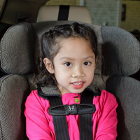 A toddler strapped in their car seat.  