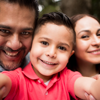 Why Prevention is the Key to Healthcare Policy All smiles as a family of three takes a selfie together.