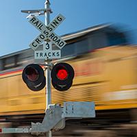 A train passing by as the railroad lights flash.