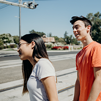 Two teens look out towards a railroad track. 