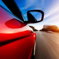 Reducing speed around schools zones The side of a red car speeding.