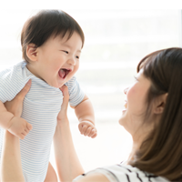 Childproofing Your Home Mother carries her smiling baby.