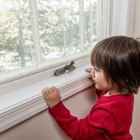 A young boy looks out a window.