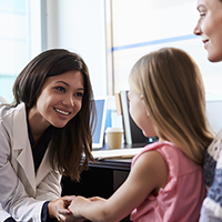 Medical professional talking to mom and kid