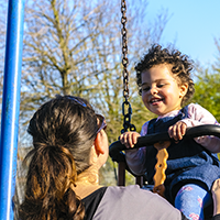 A mother keeps a close eye on her baby at the playground. 