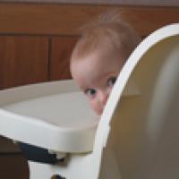 Baby properly secured in a high chair Baby properly secured in a high chair