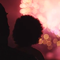 parent and child watch fireworks display from a distance