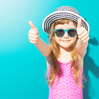 A smiling kid ready to hit the pool.