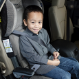 A young boy seating in his booster seat.