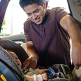 Father putting infant into car seat