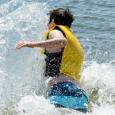 A teenage boy dives into the open wearing a life jacket. 