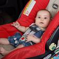 An infant strapped in their car seat. 