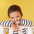 Toddler on railing of crib