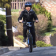 A kid bikes to school. 