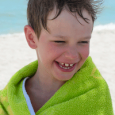 A young boy drying off after the pool.