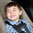 A child properly strapped into a car seat