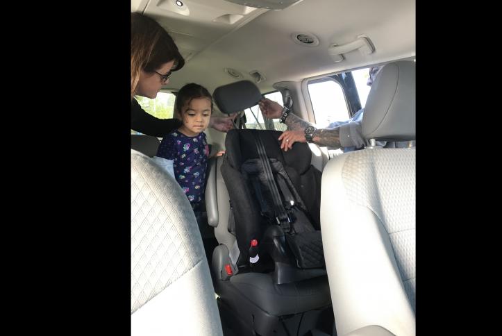 Little girl and family getting a new car seat installed at the GM Detroit Checkup Event