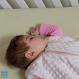 sweetest baby girl in crib with sleepsack