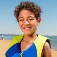 A smiling boy at the beach.