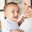 A mother holding her smiling baby. 