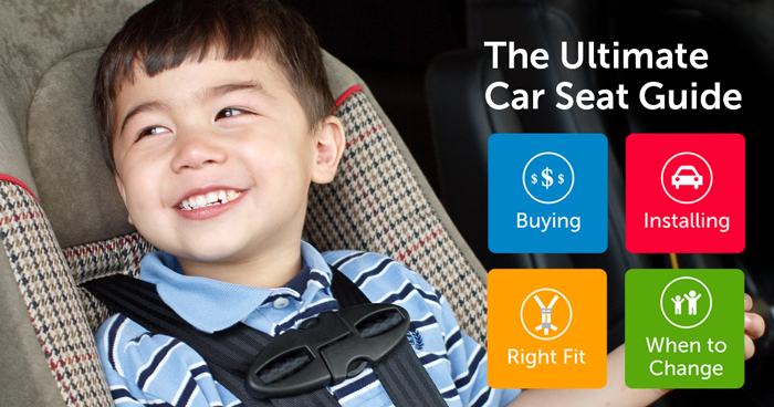 A young child smiles happily in their car seat. 