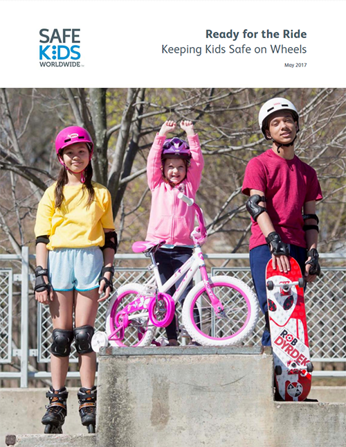 Three children standing triumphantly with their biking gear.  